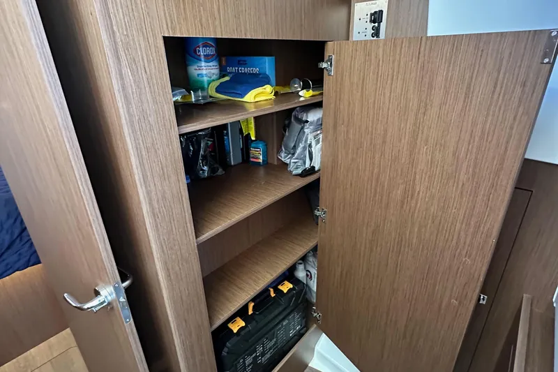 Slide: The Image of Wooden storage cabinet on Beneteau Antares 11 Fly 2023, stocked with cleaning supplies. - 56