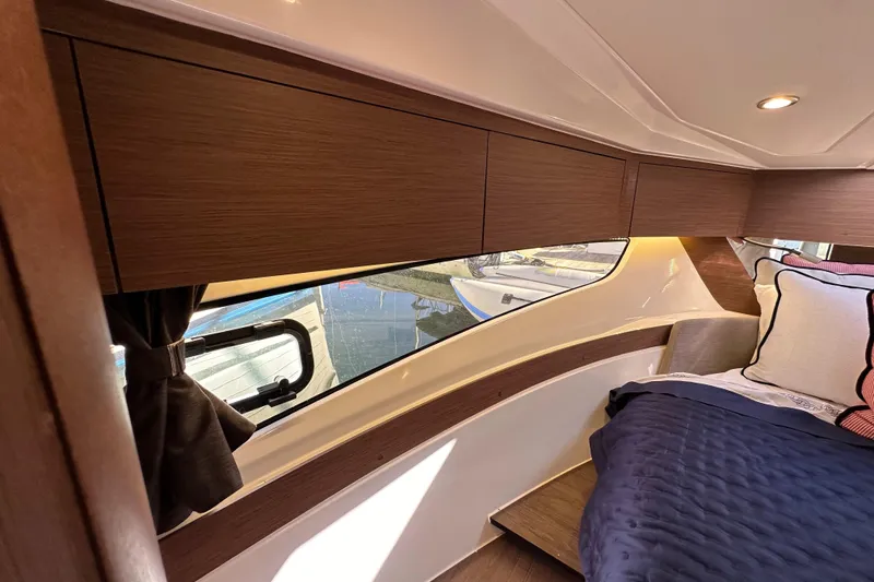 Slide: The Image of Interior cabin of 2023 Beneteau Antares 11 Fly, featuring wood cabinetry and cozy bedding. - 66