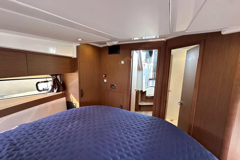 Slide: The Image of Interior cabin of 2023 Beneteau Antares 11 Fly with wood finish and blue bedding. - 68