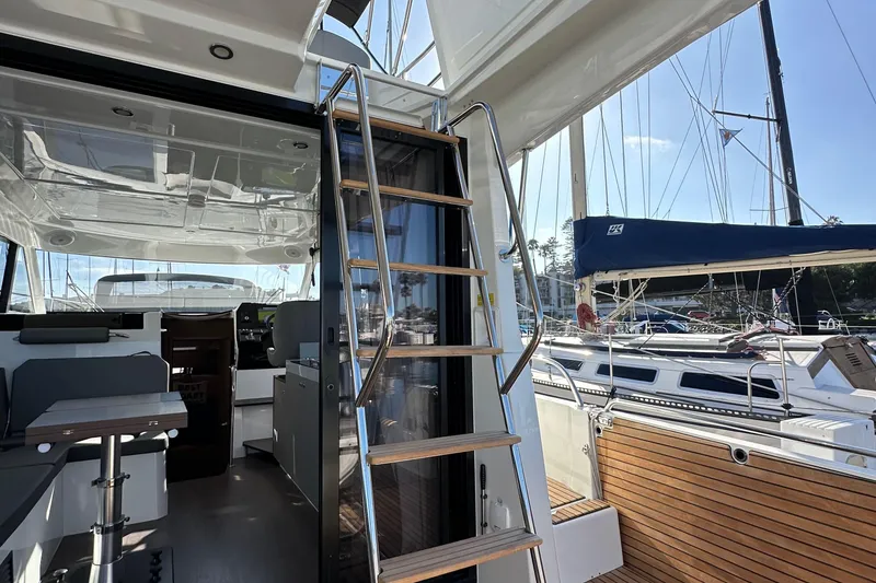 Slide: The Image of 2023 Beneteau Antares 11 Fly interior with wooden steps and marina view. - 77