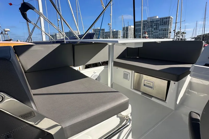 Slide: The Image of 2023 Beneteau Antares 11 Fly boat seating area with modern design and marina backdrop. - 79