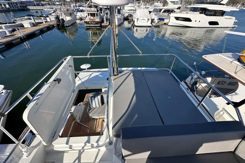 Slide: The Image of 2023 Beneteau Antares 11 Fly yacht at marina, showcasing flybridge and seating area. - 86