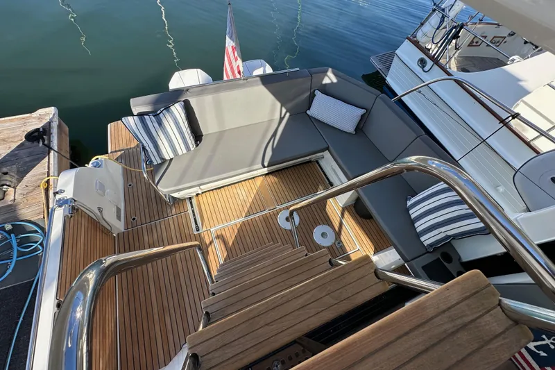 Slide: The Image of 2023 Beneteau Antares 11 Fly yacht deck with cushioned seating and wooden flooring. - 87