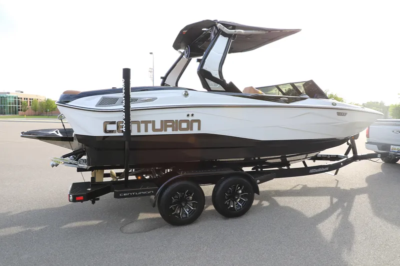 Slide: The Image of 2025 Centurion Nv213 boat on trailer, parked outdoors, showcasing sleek design and modern features. - 34