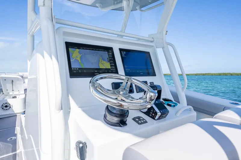 Slide: The Image of 2020 Yellowfin 34 boat dashboard with dual navigation screens and steering wheel. - 30