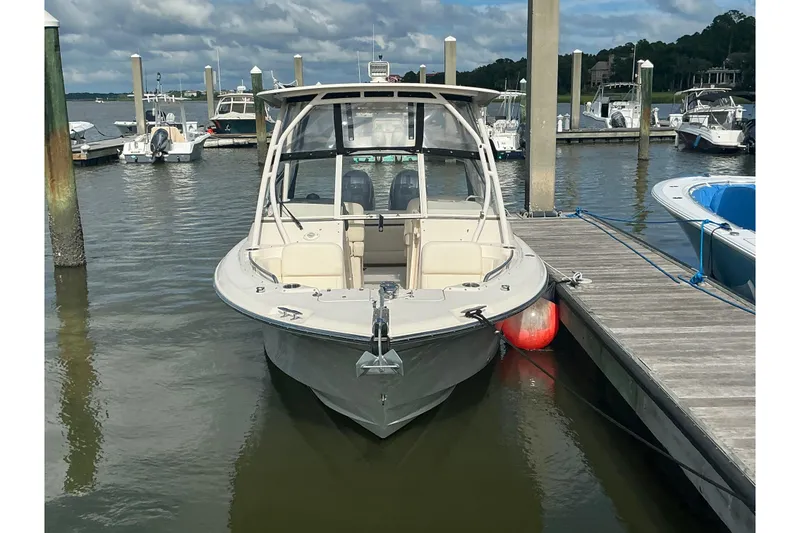 Slide: The Image of 2020 Grady-White Freedom 225 boat docked at a marina under cloudy skies. - 2