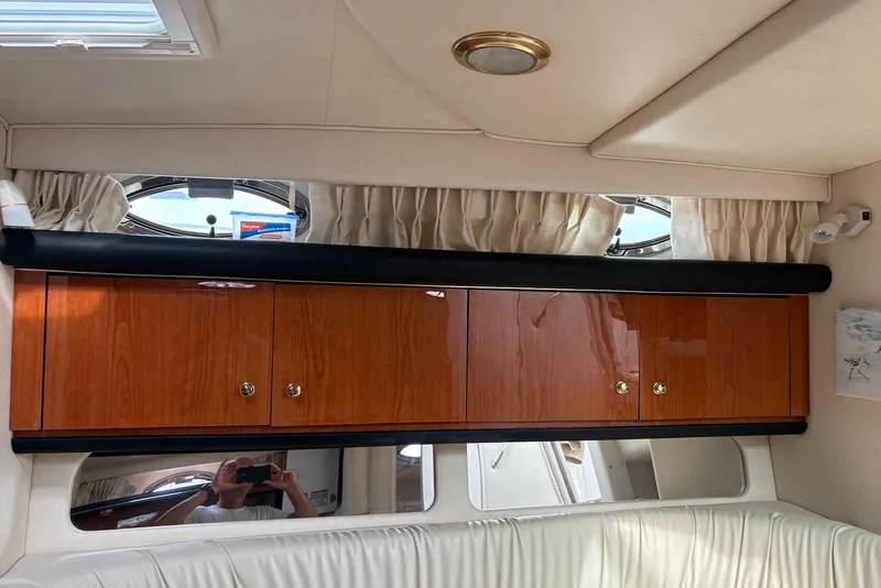 Slide: The Image of Interior of 2001 Sea Ray 340 Sundancer with wooden cabinets and porthole windows. - 11
