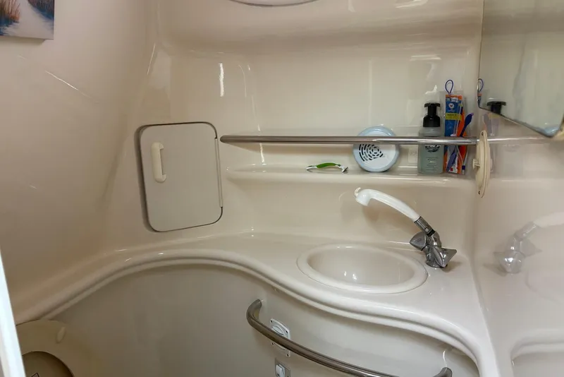 Slide: The Image of 2001 Sea Ray 340 Sundancer bathroom with sink, faucet, and toiletries on shelf. - 12