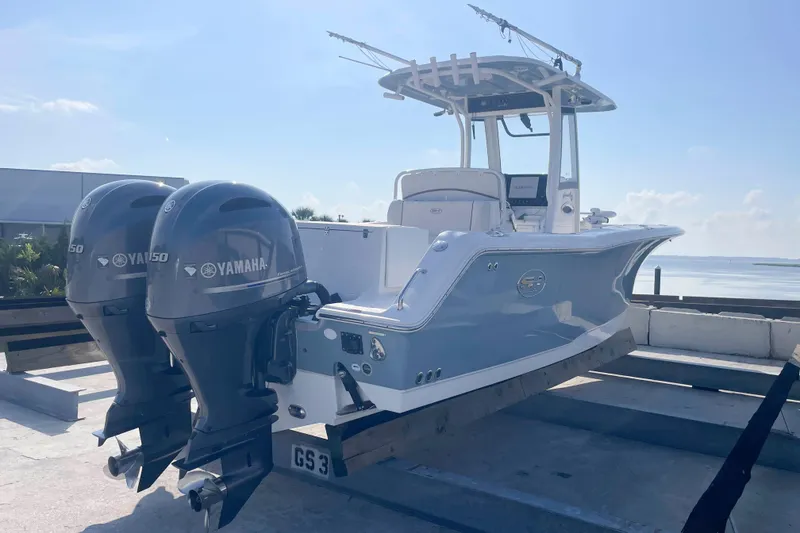 Slide: The Image of 2019 Sea Hunt Gamefish 27 boat with twin Yamaha engines, docked by the water. - 7