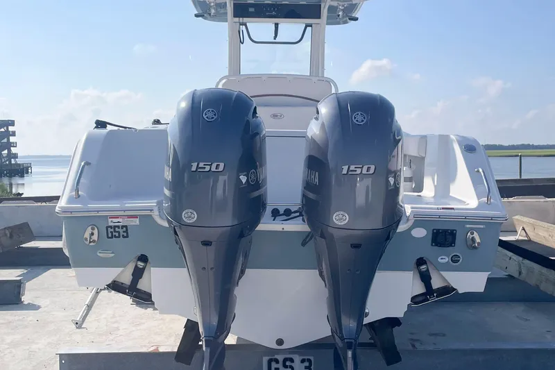 Slide: The Image of 2019 Sea Hunt Gamefish 27 boat with dual Yamaha 150 engines, docked by the water. - 8