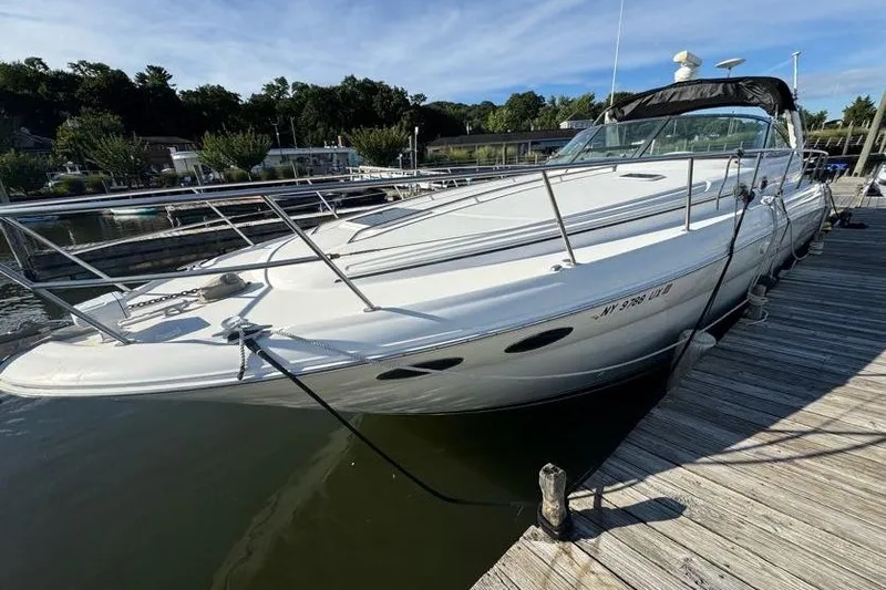Slide: The Image of 2001 Sea Ray 380 Sundancer docked at a marina, showcasing sleek design and spacious deck. - 17