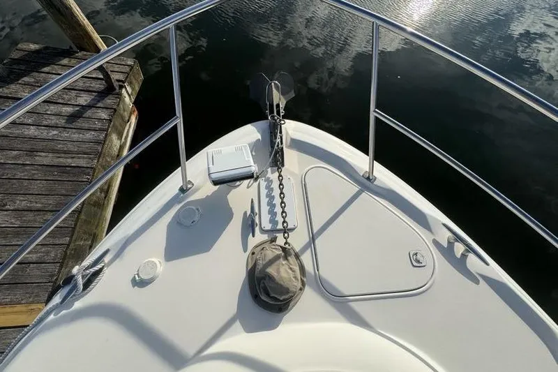 Slide: The Image of Bow of 2001 Sea Ray 380 Sundancer with anchor and railing, docked by wooden pier. - 18