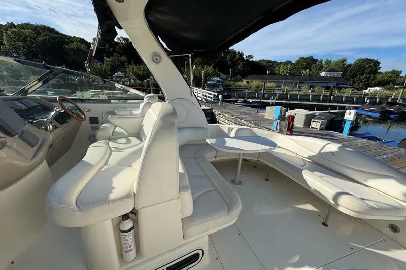 Slide: The Image of 2001 Sea Ray 380 Sundancer yacht interior with white seating and helm, docked at marina. - 19