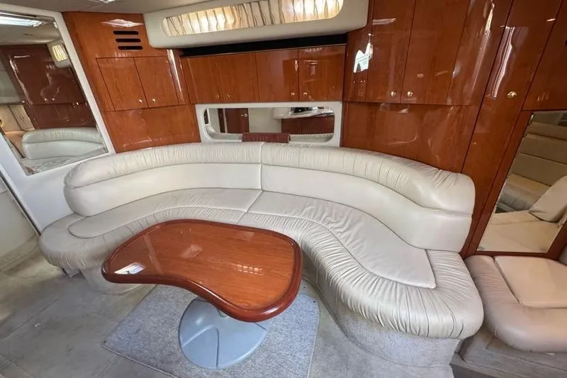 Slide: The Image of Luxurious interior of 2001 Sea Ray 380 Sundancer with curved leather seating and wooden table. - 28
