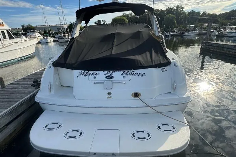 Slide: The Image of 2001 Sea Ray 380 Sundancer docked at marina, rear view with black cover. - 4