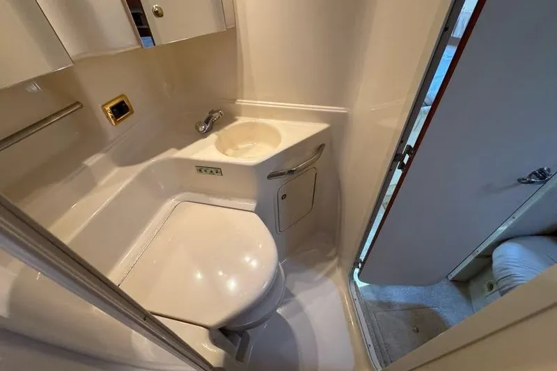Slide: The Image of Compact bathroom in a 2001 Sea Ray 380 Sundancer yacht, featuring a toilet and sink. - 40