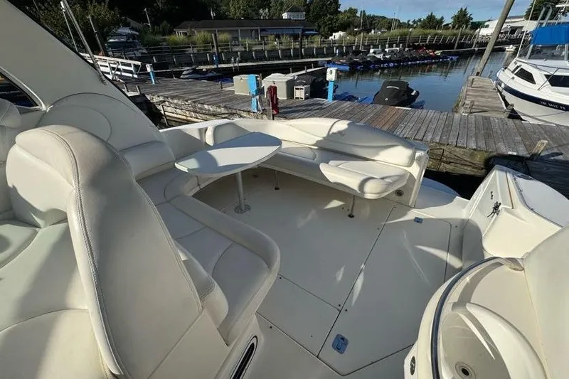 Slide: The Image of 2001 Sea Ray 380 Sundancer yacht interior with white seating and table at marina. - 44