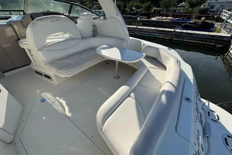 Slide: The Image of 2001 Sea Ray 380 Sundancer boat interior with white seating and table, docked at marina. - 46