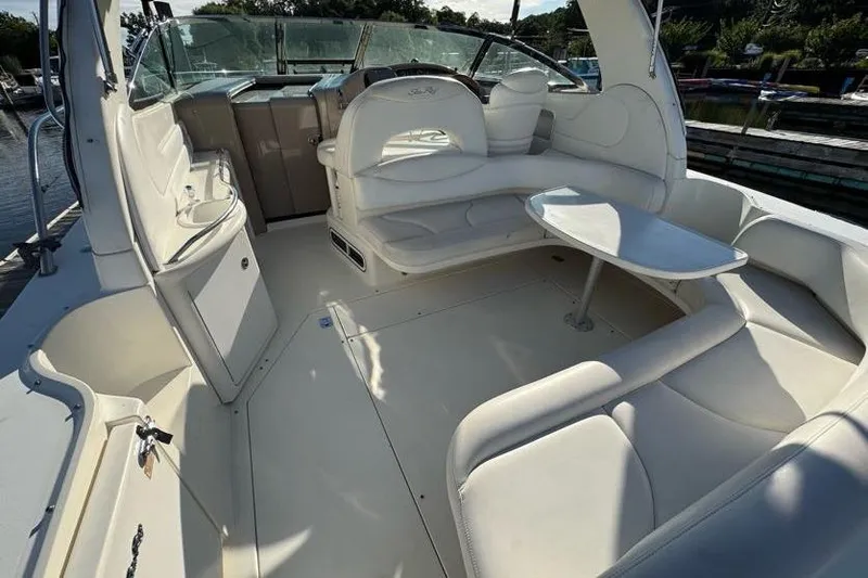 Slide: The Image of 2001 Sea Ray 380 Sundancer interior with white seating and table, docked by the water. - 47