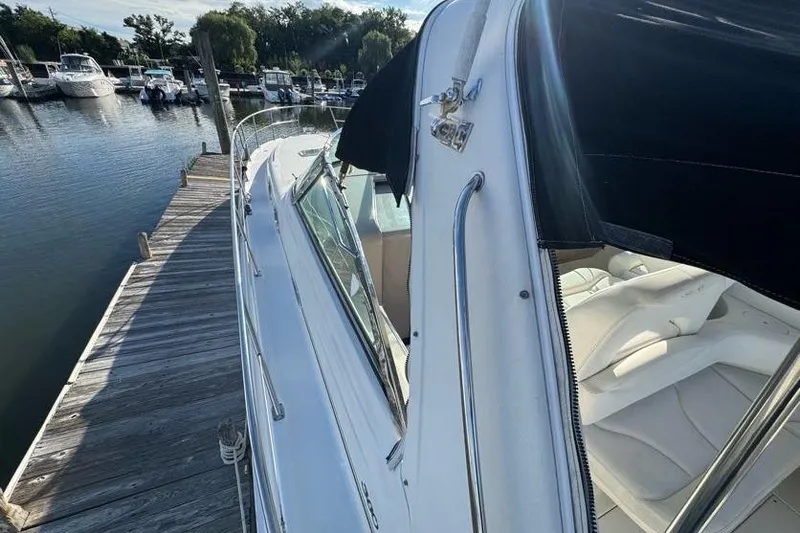 Slide: The Image of 2001 Sea Ray 380 Sundancer docked at marina, showcasing sleek design and comfortable seating. - 48