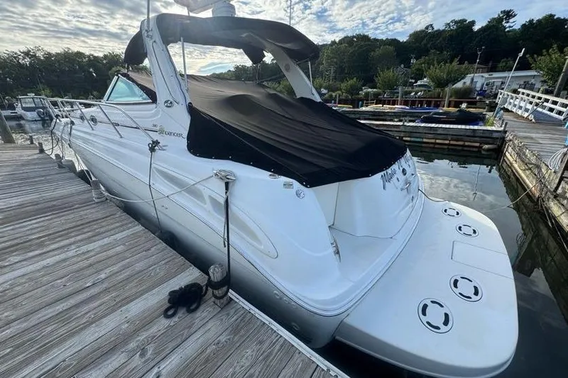 Slide: The Image of 2001 Sea Ray 380 Sundancer docked, featuring sleek design and black cover. - 5