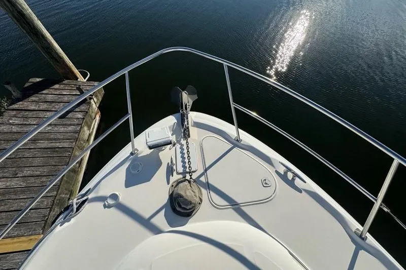 Slide: The Image of Bow view of 2001 Sea Ray 380 Sundancer yacht docked by calm water. - 50