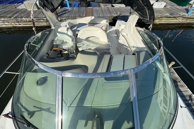 Slide: The Image of 2001 Sea Ray 380 Sundancer boat interior with seating and controls, docked at marina. - 53