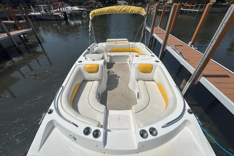 Slide: The Image of 2014 Hurricane SunDeck Sport 188 IO boat with yellow seating, docked by wooden piers. - 3