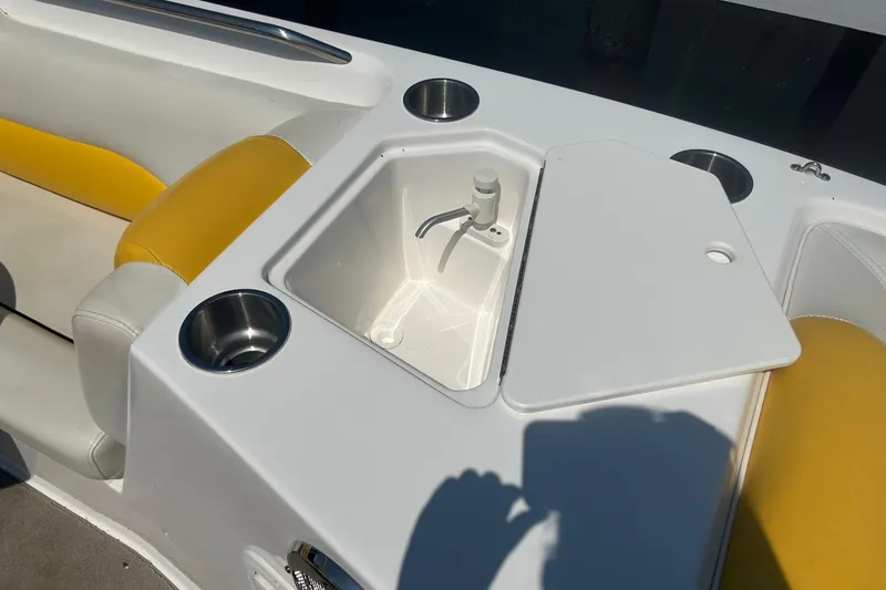 Slide: The Image of 2014 Hurricane SunDeck Sport 188 IO boat interior with sink and yellow seating. - 7