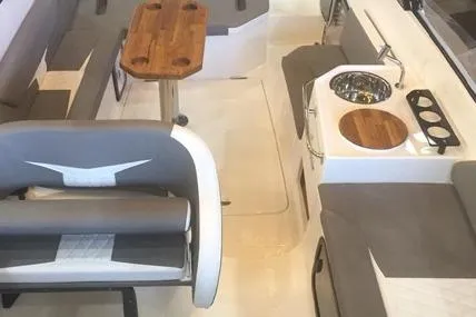 Slide: The Image of Interior of 2025 Hanover 305 Gray & Black Edition boat with seating and kitchenette. - 3