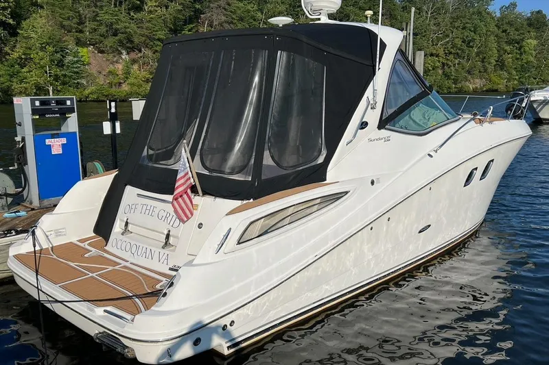 The Image of 2012 Sea Ray 330 Sundancer docked, featuring "Off the Grid" name and American flag. - 0