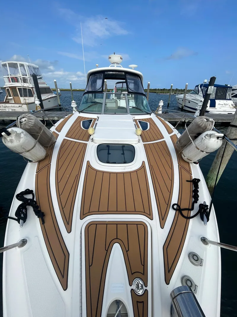 Slide: The Image of 2012 Sea Ray 330 Sundancer docked, showcasing sleek design and spacious deck. - 11