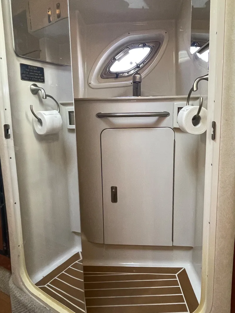 Slide: The Image of 2012 Sea Ray 330 Sundancer bathroom with modern fixtures and porthole window. - 22