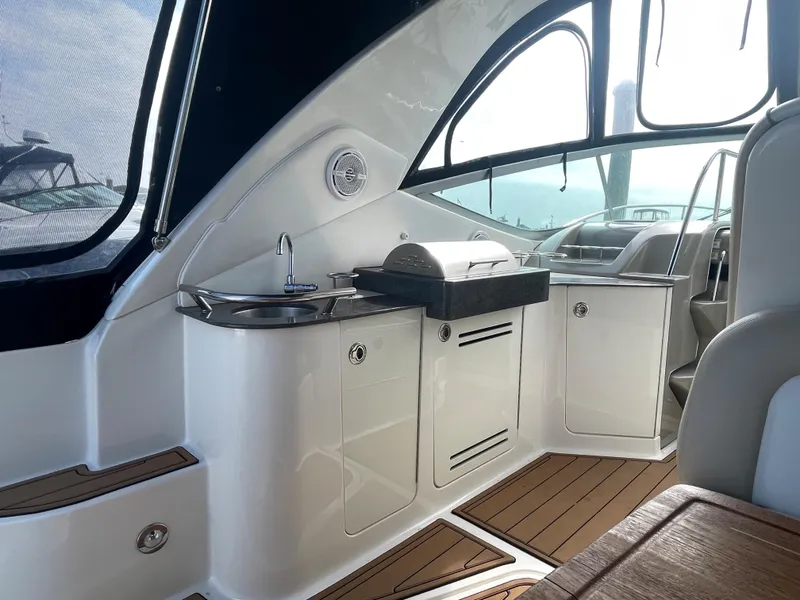 Slide: The Image of 2012 Sea Ray 330 Sundancer yacht interior with kitchenette and seating area. - 6