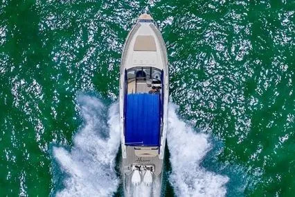 Slide: The Image of Aerial view of 2024 Hanover 305 White & Blue Edition boat cruising on vibrant green water. - 3