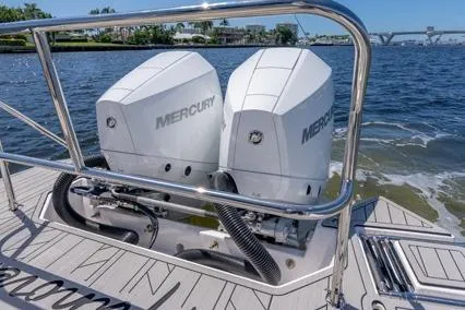 Slide: The Image of 2024 Hanover 305 White & Blue Edition boat with dual Mercury outboard engines on a sunny day. - 8