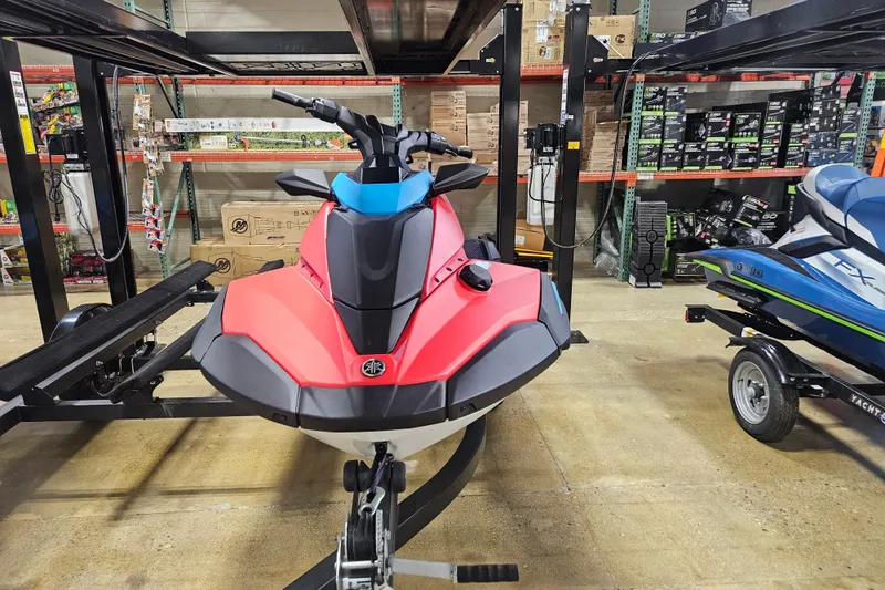 Slide: The Image of 2025 Yamaha WaveRunner Jet Blaster DLX 3 Pass in showroom, vibrant red and black design. - 1