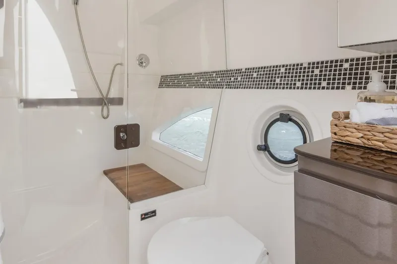 Slide: The Image of Modern bathroom interior in 2024 Hanover 415 Pure Gray yacht, featuring shower and porthole window. - 14