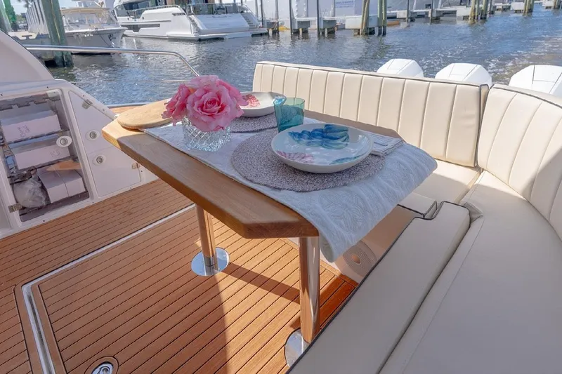 Slide: The Image of Luxurious dining setup on 2024 Hanover 415 Pure Gray yacht, featuring elegant tableware and pink flowers. - 8