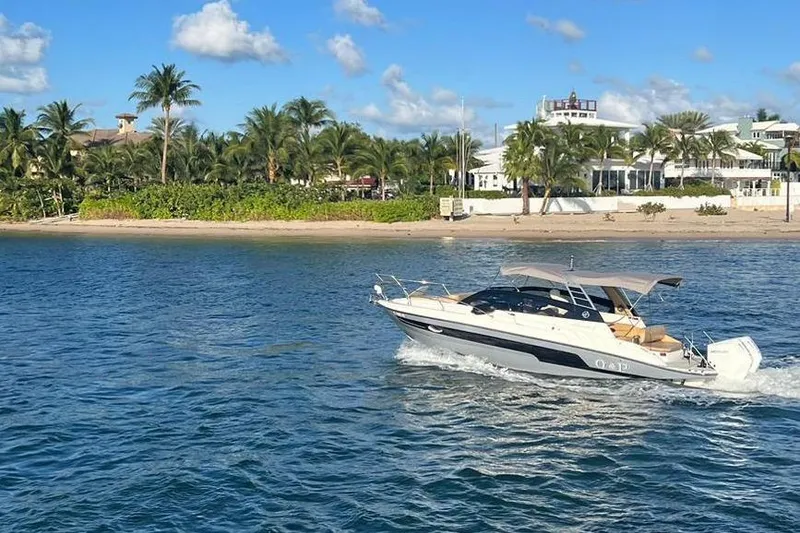 Slide: The Image of 2024 Hanover 305 White & Gray Edition boat cruising near tropical shoreline. - 12