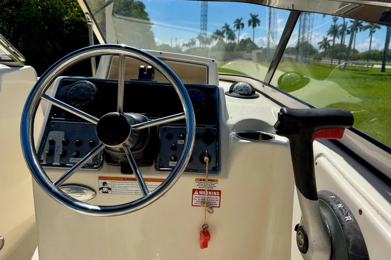 Slide: The Image of 2021 Scout 210 Dorado boat dashboard with steering wheel and controls. - 16