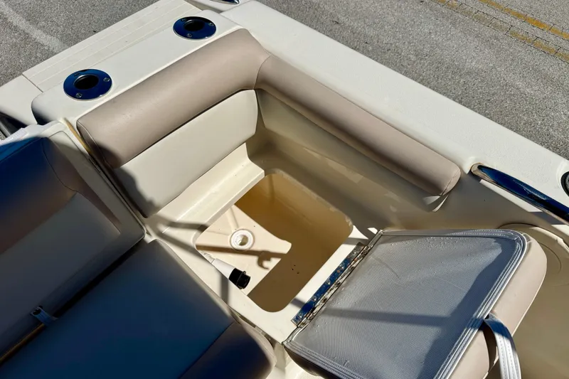 Slide: The Image of 2021 Scout 210 Dorado boat interior with open storage compartment and cup holders. - 21