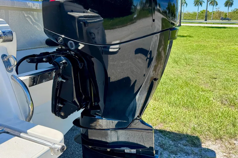 Slide: The Image of 2021 Scout 210 Dorado boat engine, shiny black finish, parked on grass. - 23