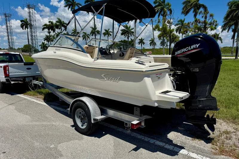 Slide: The Image of 2021 Scout 210 Dorado boat on trailer with Mercury engine, parked near palm trees. - 7