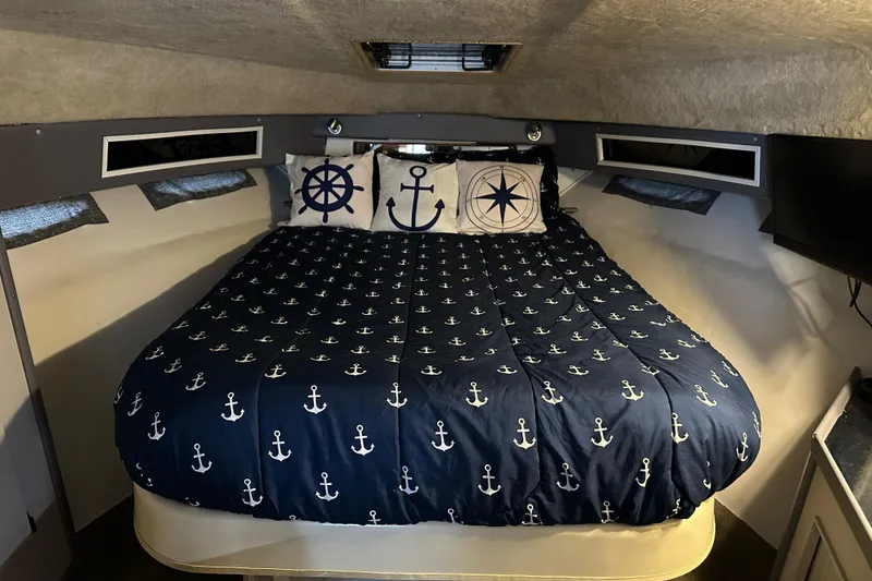 Slide: The Image of Interior of 1986 Sea Ray 340 Express Cruiser with nautical-themed decor and cozy seating. - 15