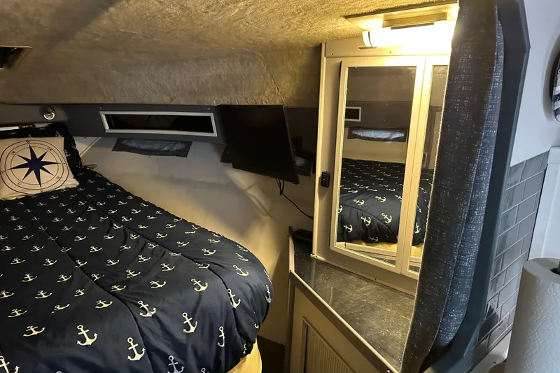 Slide: The Image of 1986 Sea Ray 340 Express Cruiser interior with nautical decor and cozy seating area. - 16