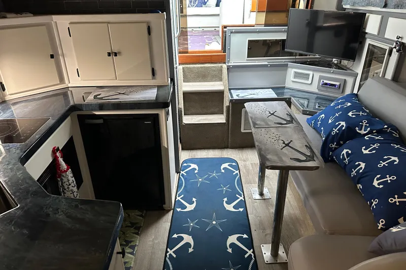 Slide: The Image of 1986 Sea Ray 340 Express Cruiser kitchen with black countertops and white cabinets. - 17