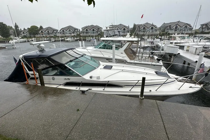 Slide: The Image of 1986 Sea Ray 340 Express Cruiser docked at marina with American flag. - 2