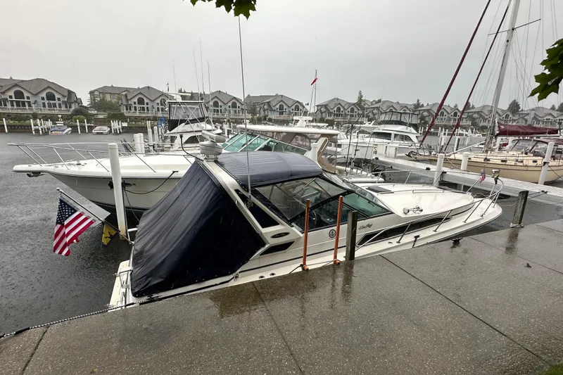 Slide: The Image of 1986 Sea Ray 340 Express Cruiser docked at a scenic marina. - 3