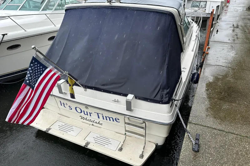 Slide: The Image of 1986 Sea Ray 340 Express Cruiser docked at marina, blue canopy, sunny day. - 4